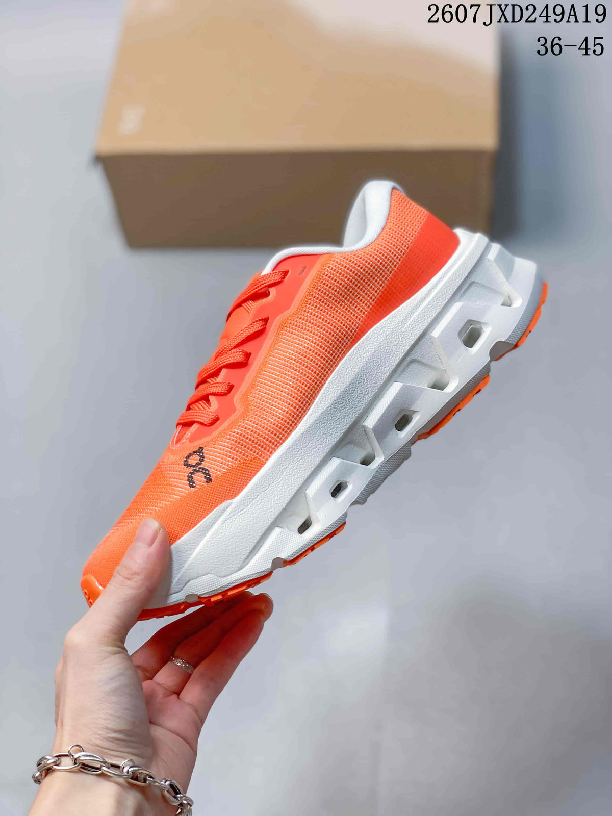 Side profile of an orange lace-up sneaker showing the textured upper and geometric openings in the white midsole.