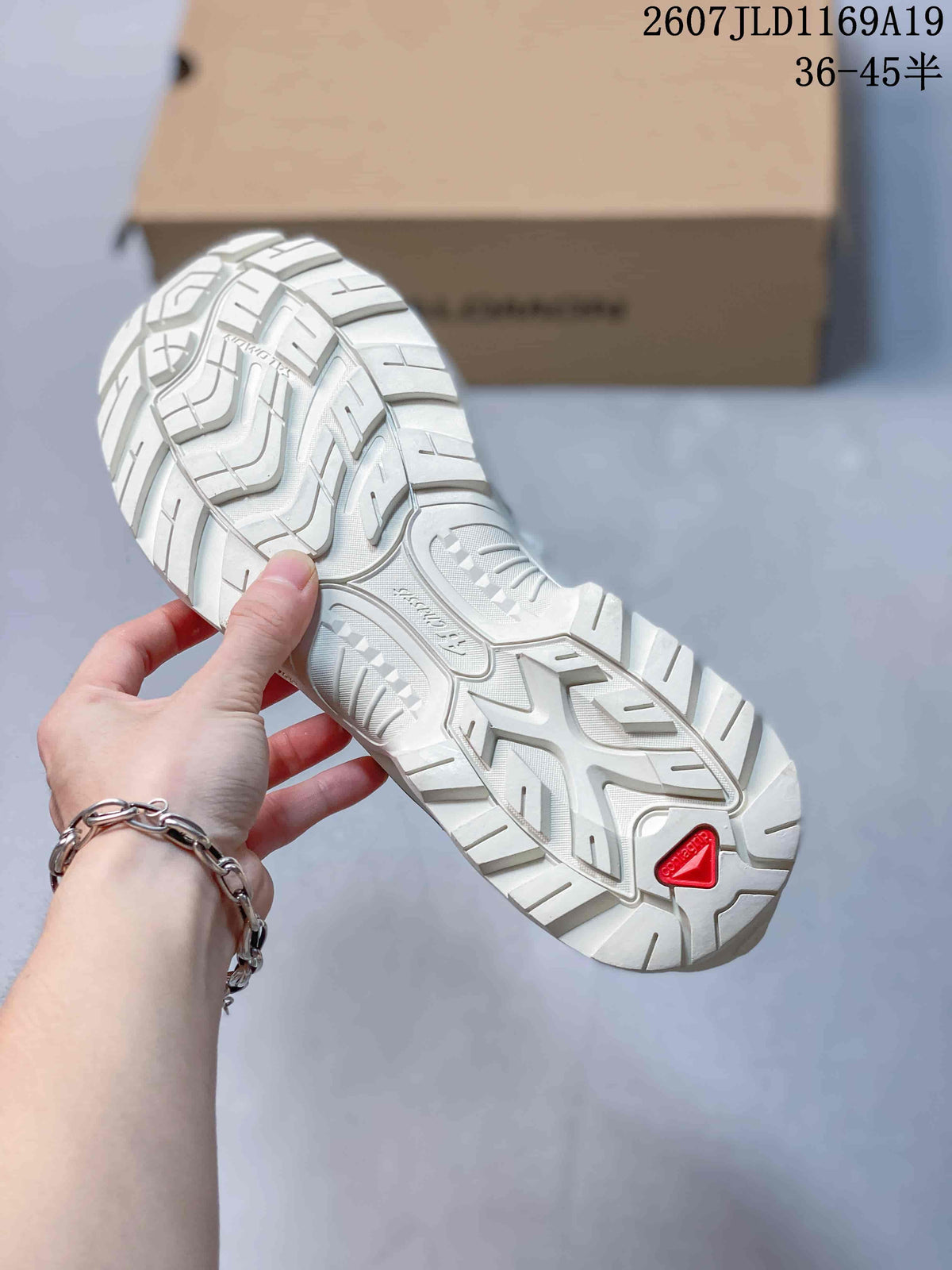 Close-up of the Salomon XT-Quest outsole showing a white lugged tread pattern and red outsole branding detail.