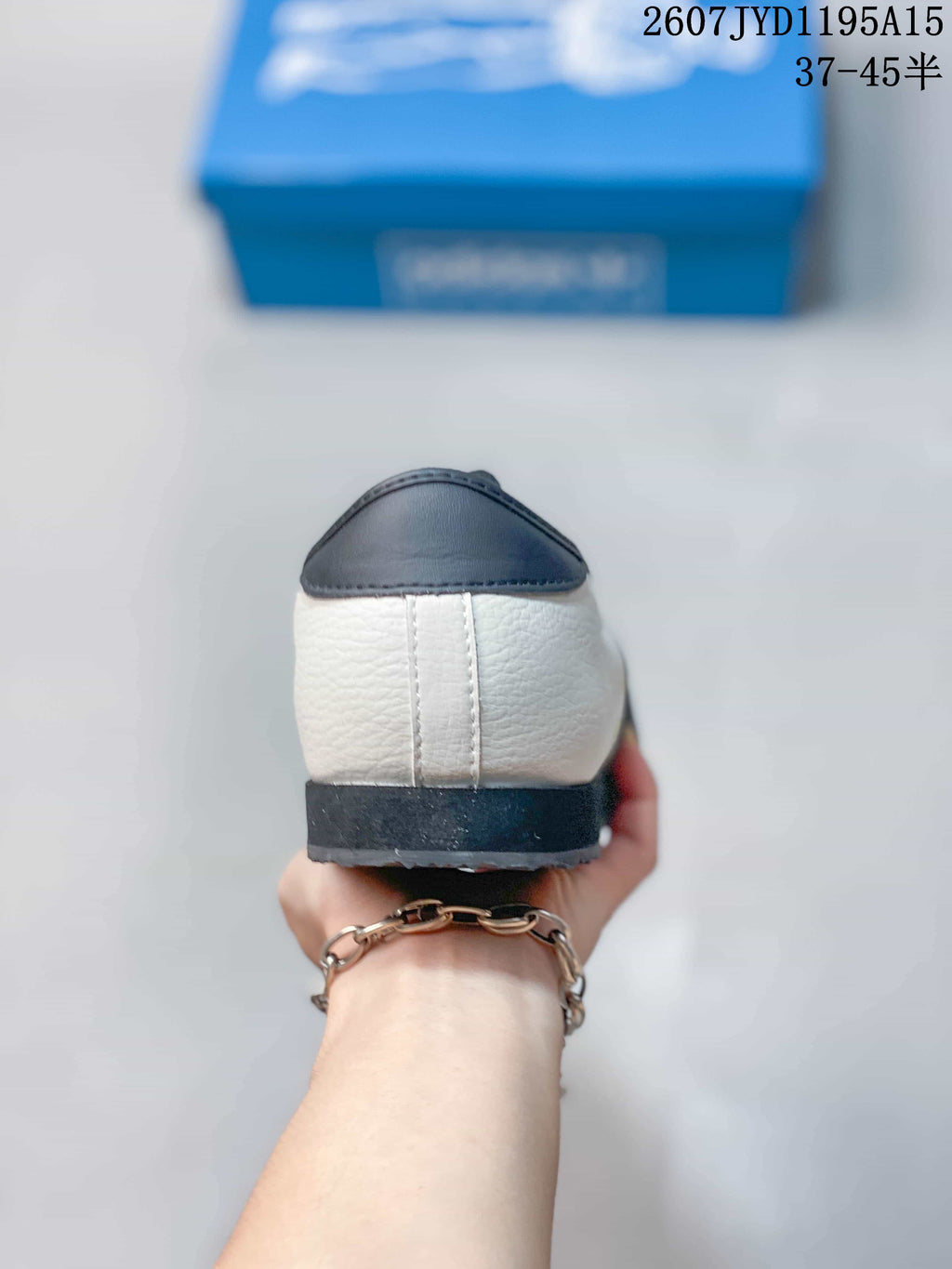 Rear view showing the navy heel panel, off-white upper, and dark outsole.
