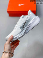 Side profile of the white Nike running sneaker showing the Swoosh, breathable-looking upper panels, raised heel, and gray outsole detail.