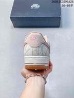 Rear view of sneaker with textured panels and pink heel branding