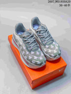 Pair of gray Nike Air Pegasus Premium sneakers with floral graphics displayed on an orange shoebox.