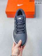 Top-down view of the gray lace-up sneaker showing the padded tongue, laces, mesh-textured toe box, and side detailing.