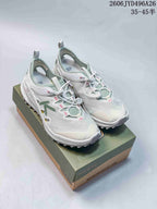White Keen Zionic ADV low-top hiking shoes with green and pink accents, shown on a shoe box