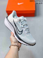 Close-up of a white Nike Quest 6 sneaker with black and blue detailing around the upper and sole.