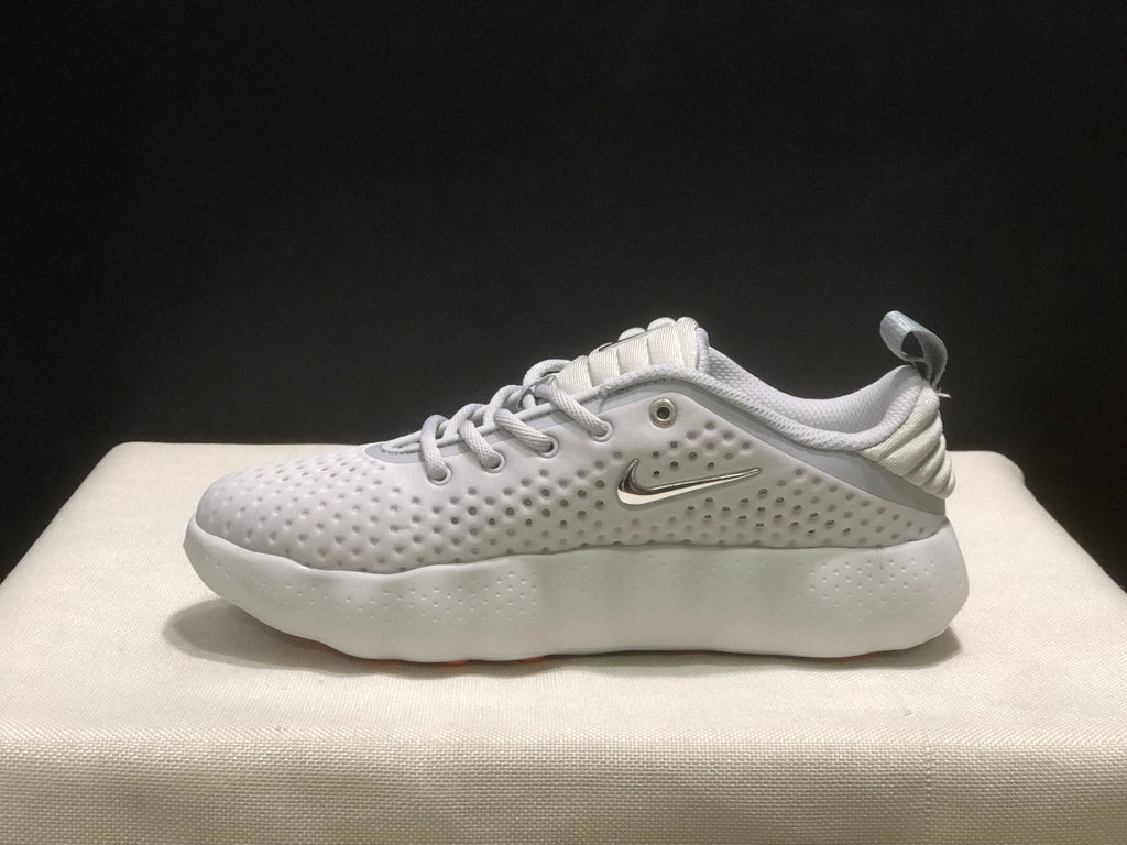 Side profile of a white sneaker showing the metallic-colored side logo, perforated upper and cushioned-looking sole.