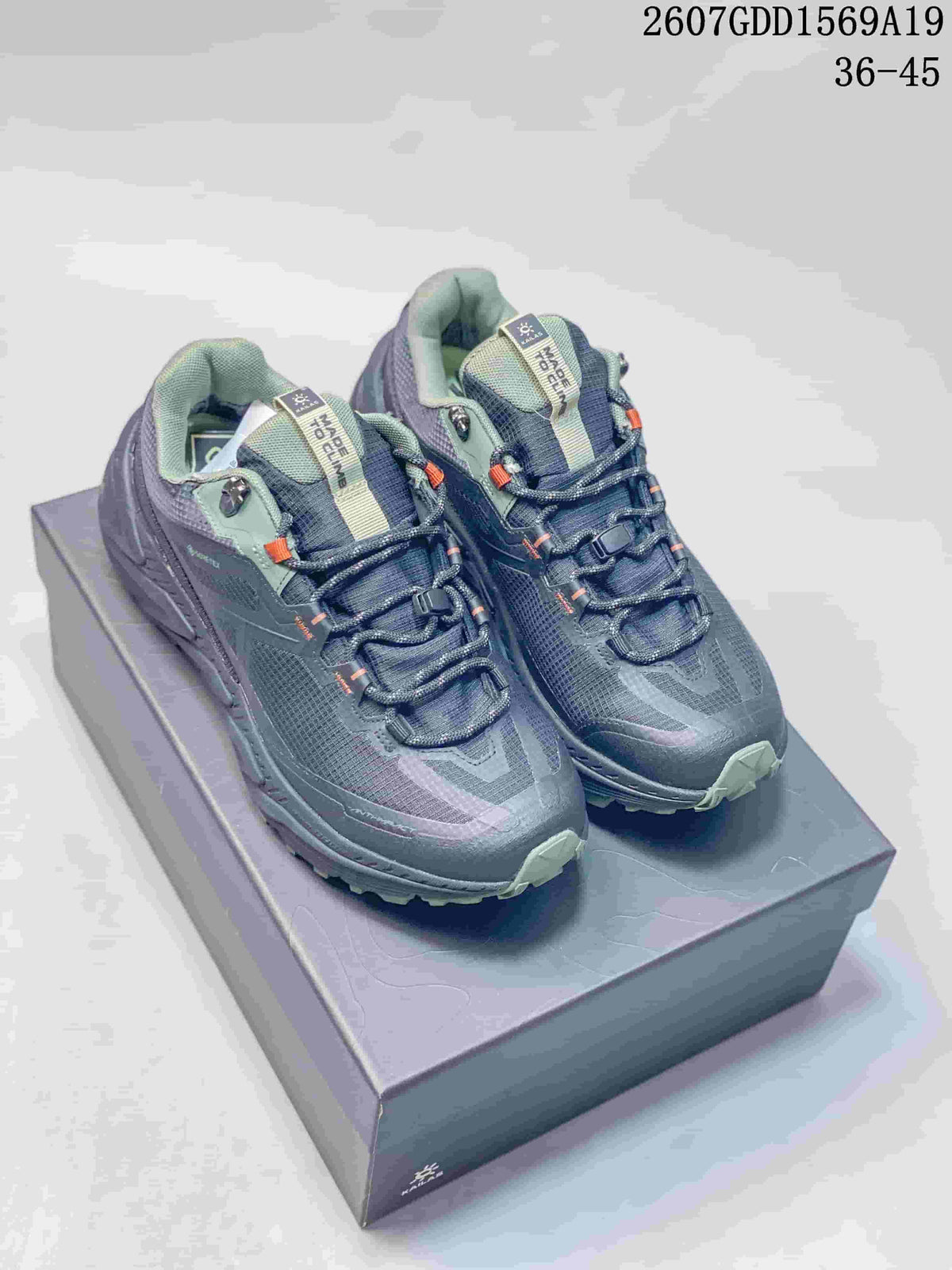 Pair of dark gray and green-accented KAILAS trail shoes displayed on a shoebox.