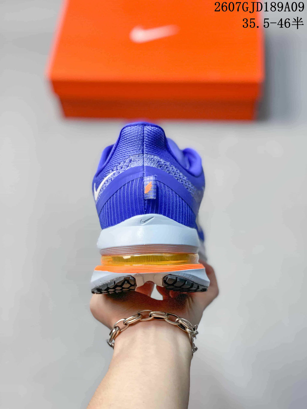 Rear view of the blue running shoe showing the heel structure, white midsole and translucent orange cushioning unit.