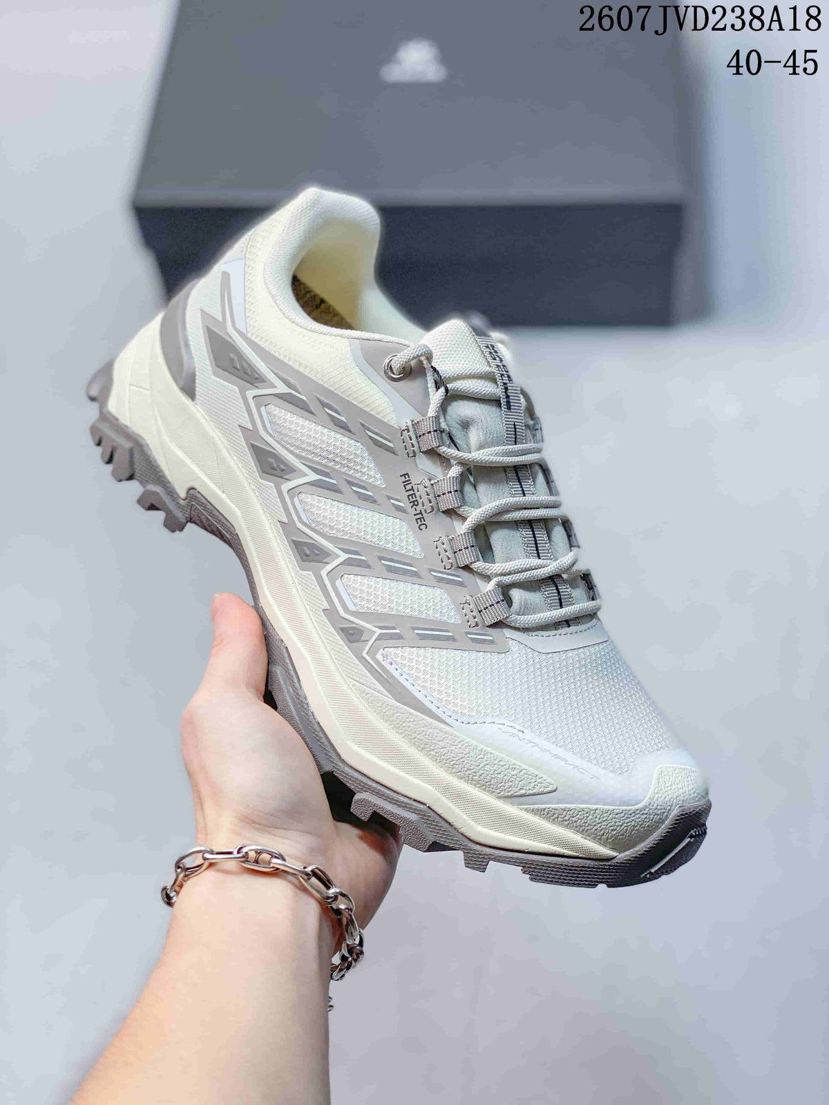Close view of a white KAILAS hiking shoe showing the mesh-style upper, layered side overlays, padded collar, and lugged outsole.