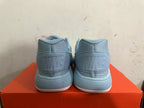 Rear view of light blue Nike basketball shoes with ridged soles.