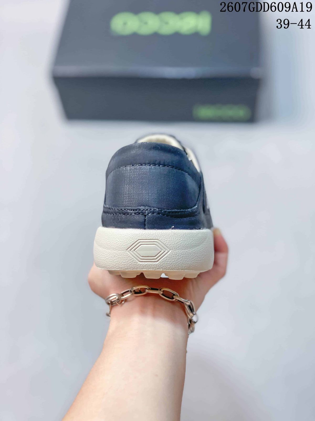 Rear view of the navy sneaker showing the heel panel, contrast sole, and embossed geometric detail.