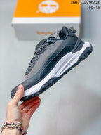 Side profile showing the mesh-look upper, lace system, dark overlays, and layered white midsole.