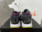 Rear view of black and burgundy Nike basketball shoes with a speckled white midsole and bright yellow-green outsole.