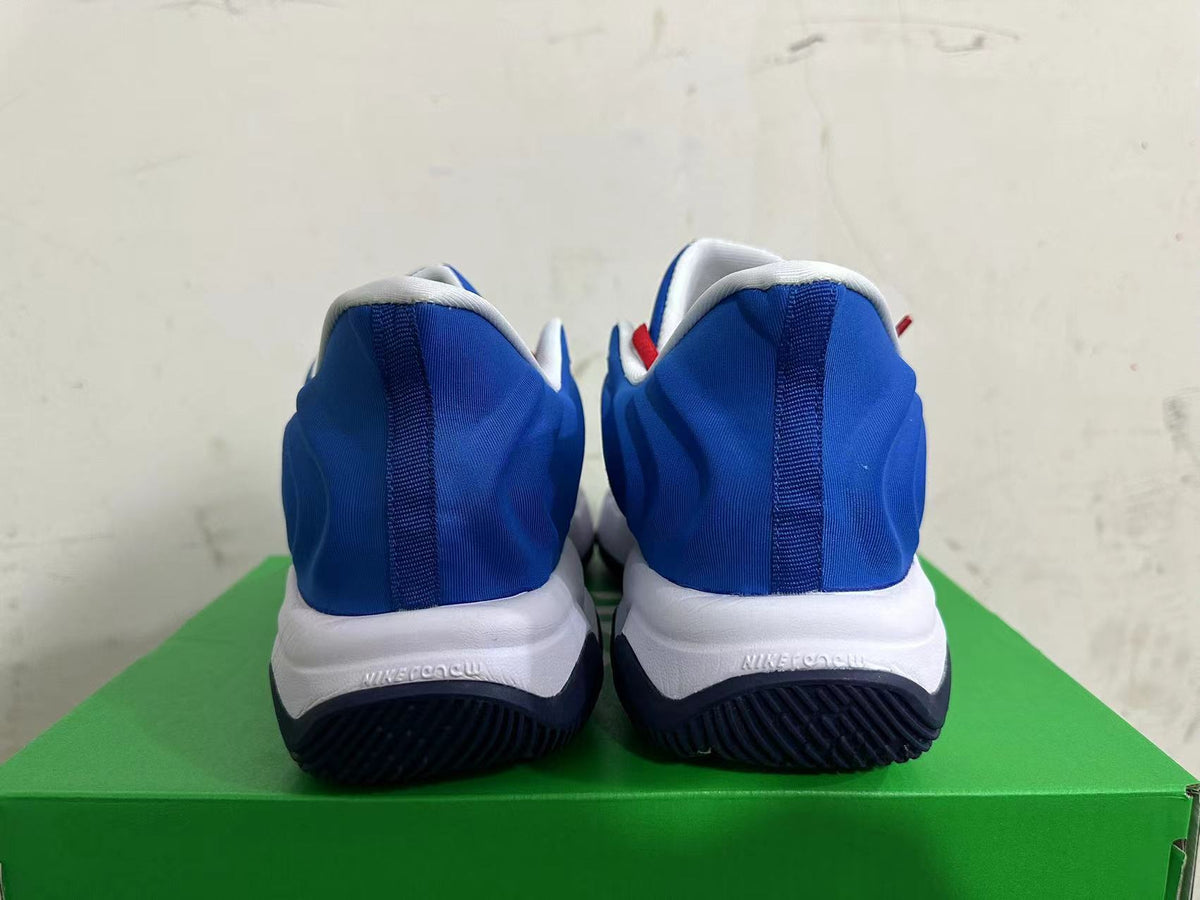 Rear view of white and blue Nike basketball shoes with dark outsoles.