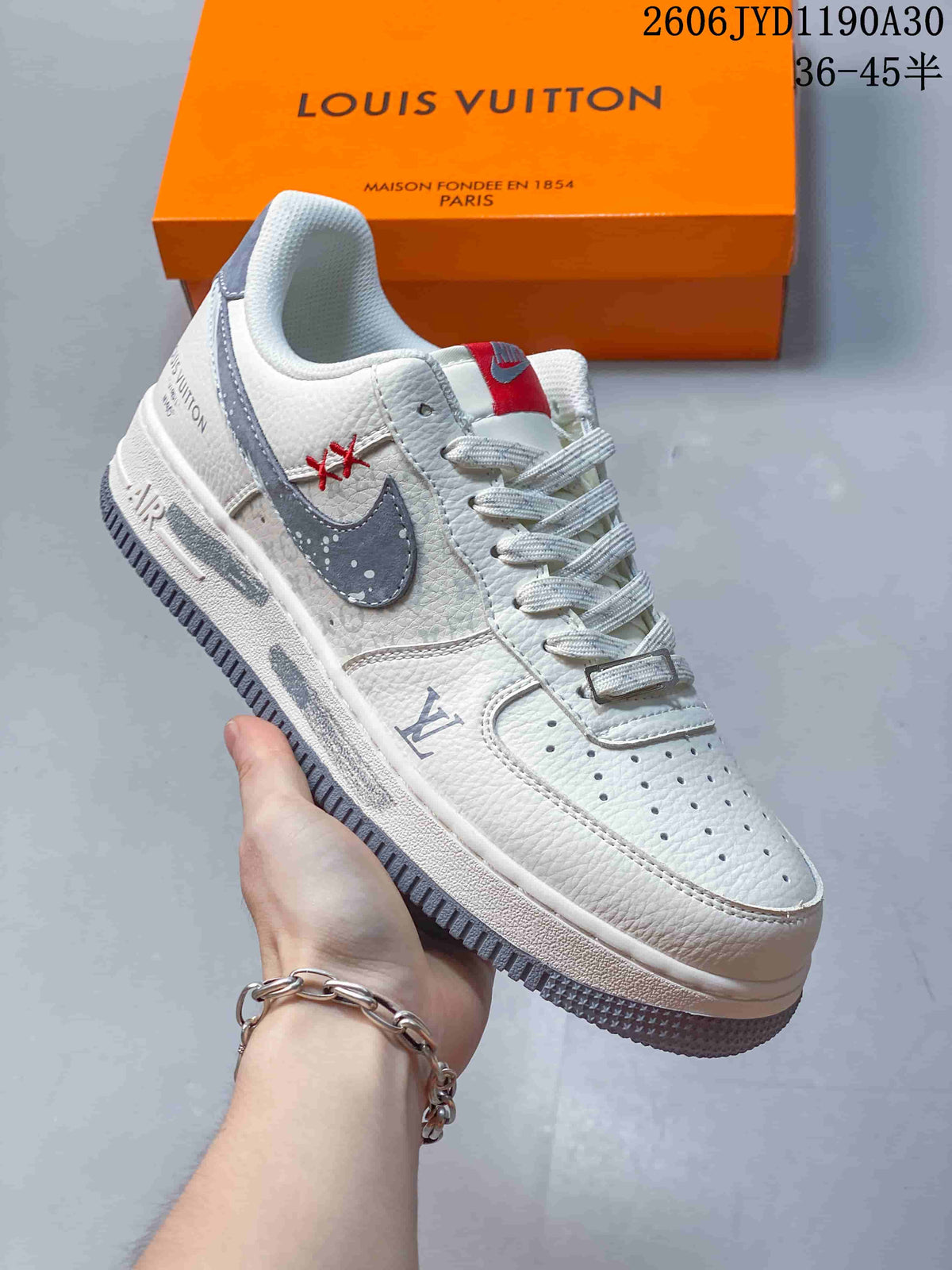 Angled view of the sneaker showing its off-white upper, gray accents, and side branding