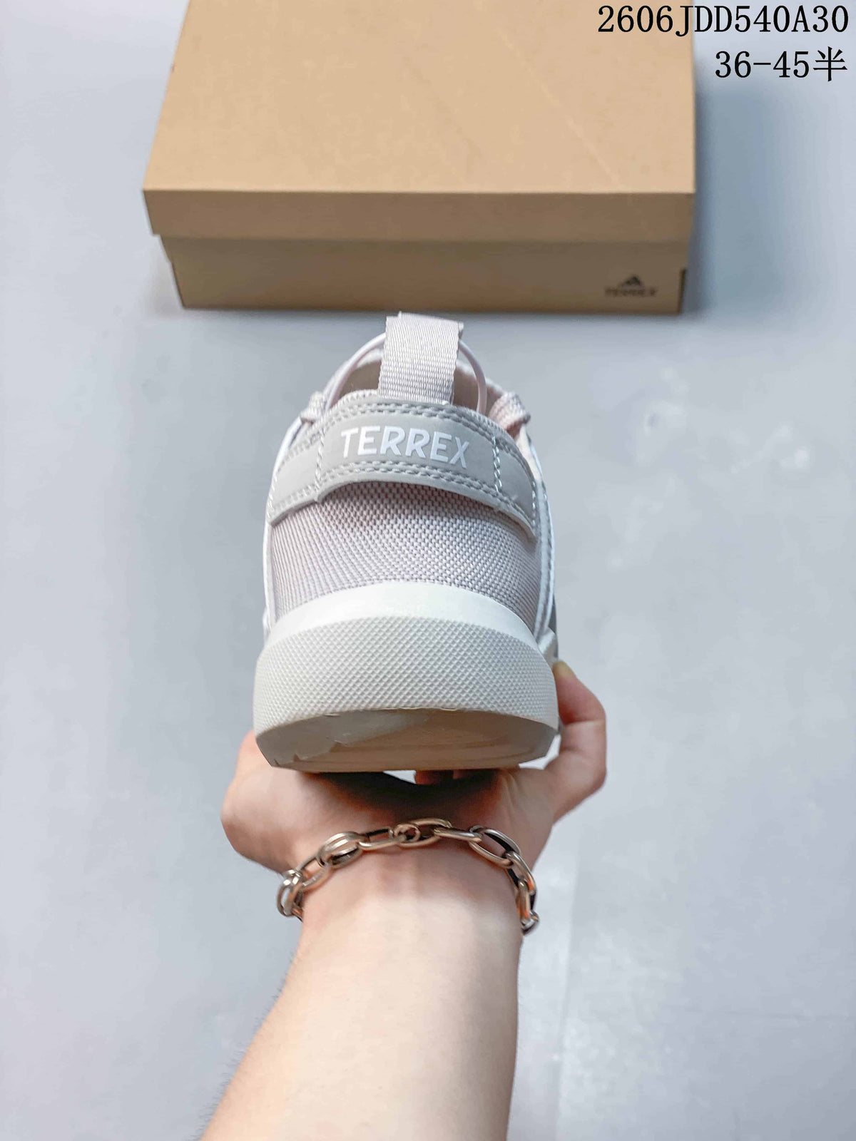 Rear view of a light gray Adidas Terrex sneaker with heel pull tab