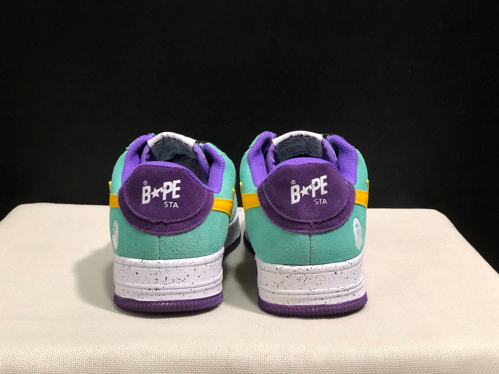 Rear view of the pair showing purple heel panels, mint green uppers, white heel graphics, and Bape Sta branding.