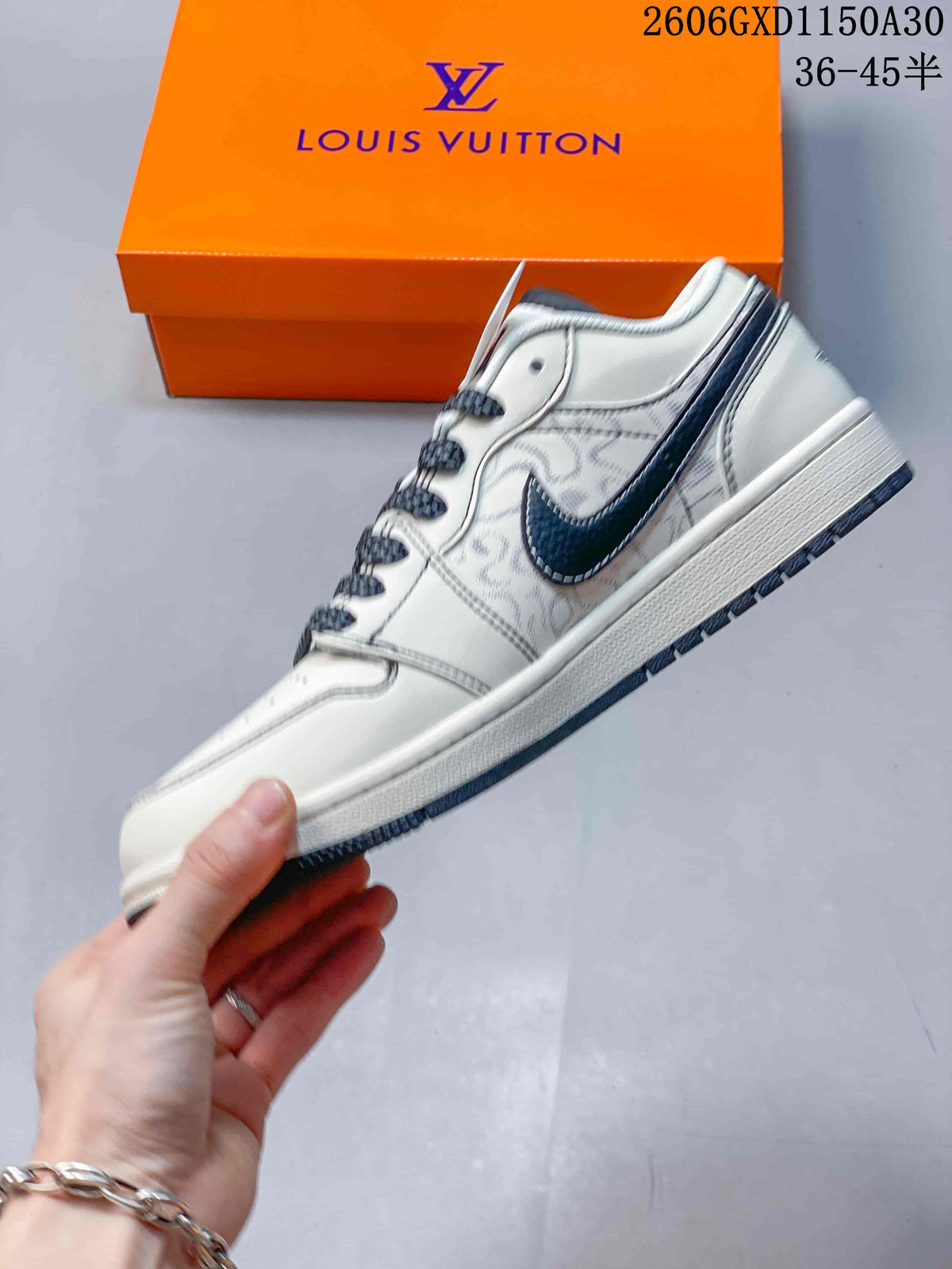 Side profile of a cream low-top sneaker with patterned panels and a dark Swoosh