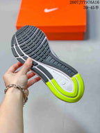 Close view of the sneaker outsole showing segmented black tread, a white midsole, and neon green heel accents.