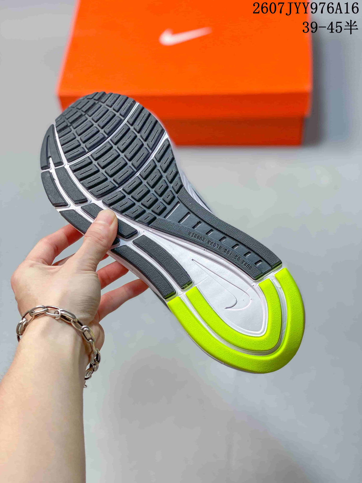Close view of the sneaker outsole showing segmented black tread, a white midsole, and neon green heel accents.