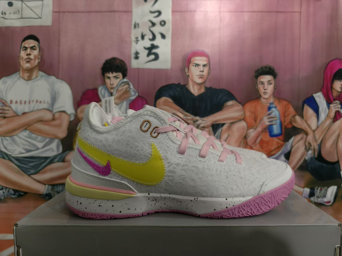 Side view of a white Nike basketball sneaker with yellow and purple-pink Swoosh details