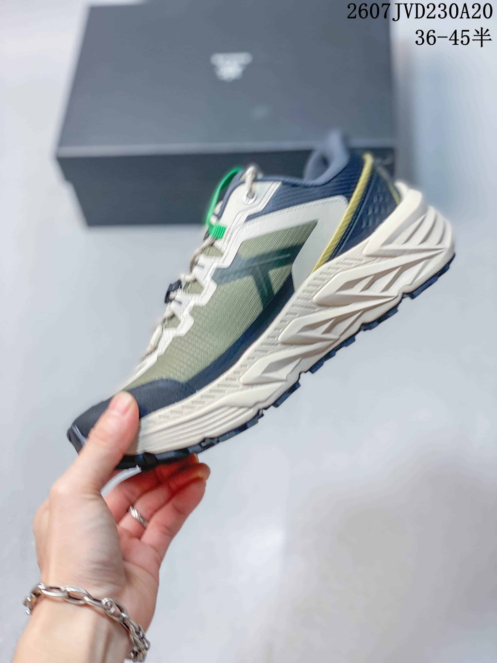 Side view showing the green mesh-like upper, navy overlays, white support panels and sculpted midsole.