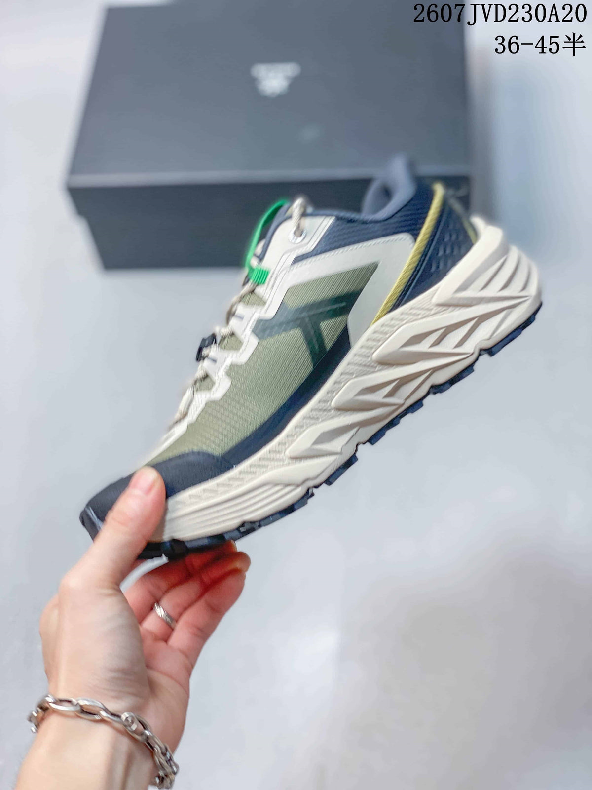 Side view showing the green mesh-like upper, navy overlays, white support panels and sculpted midsole.