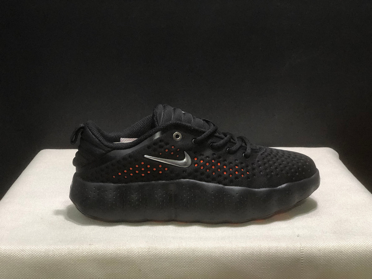 Side view of a black sneaker with orange accents visible through the perforations and a silver-colored side logo.