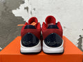 Rear view of red, navy, and white Nike Kobe basketball shoes with signature heel details