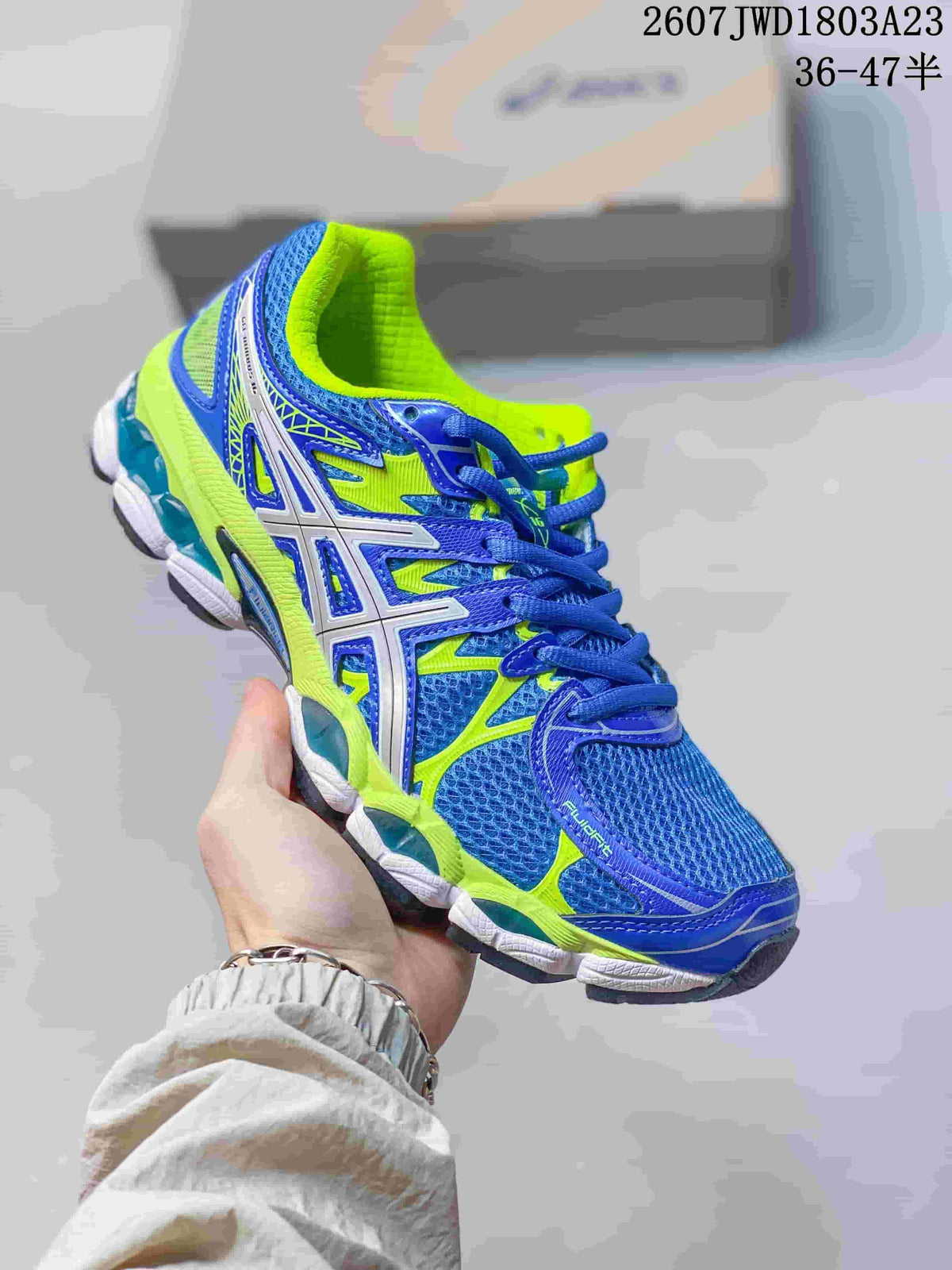 Blue and neon green ASICS Gel-Nimbus 16 sneaker with white side overlays.