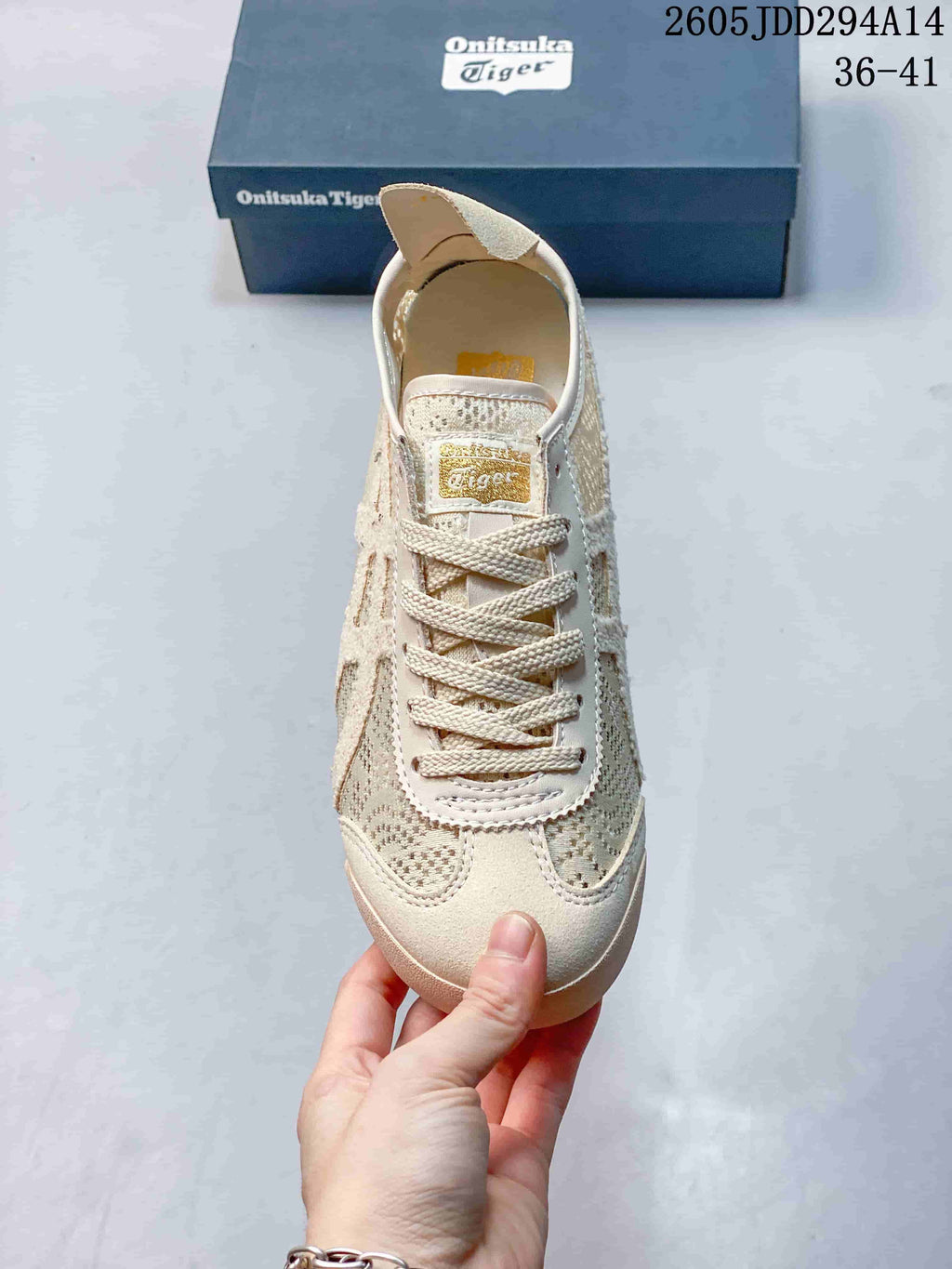 Top view of the sneaker showing the rounded toe, lace-up fastening, tongue label, and patterned textile panels.
