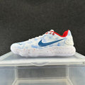 Side view of a white and pale-blue Nike low-top shoe with a blue Swoosh, red lining, and speckled white sole.