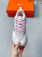 Top view of a Nike Vomero Plus shoe with pale pink laces and a textured white upper.