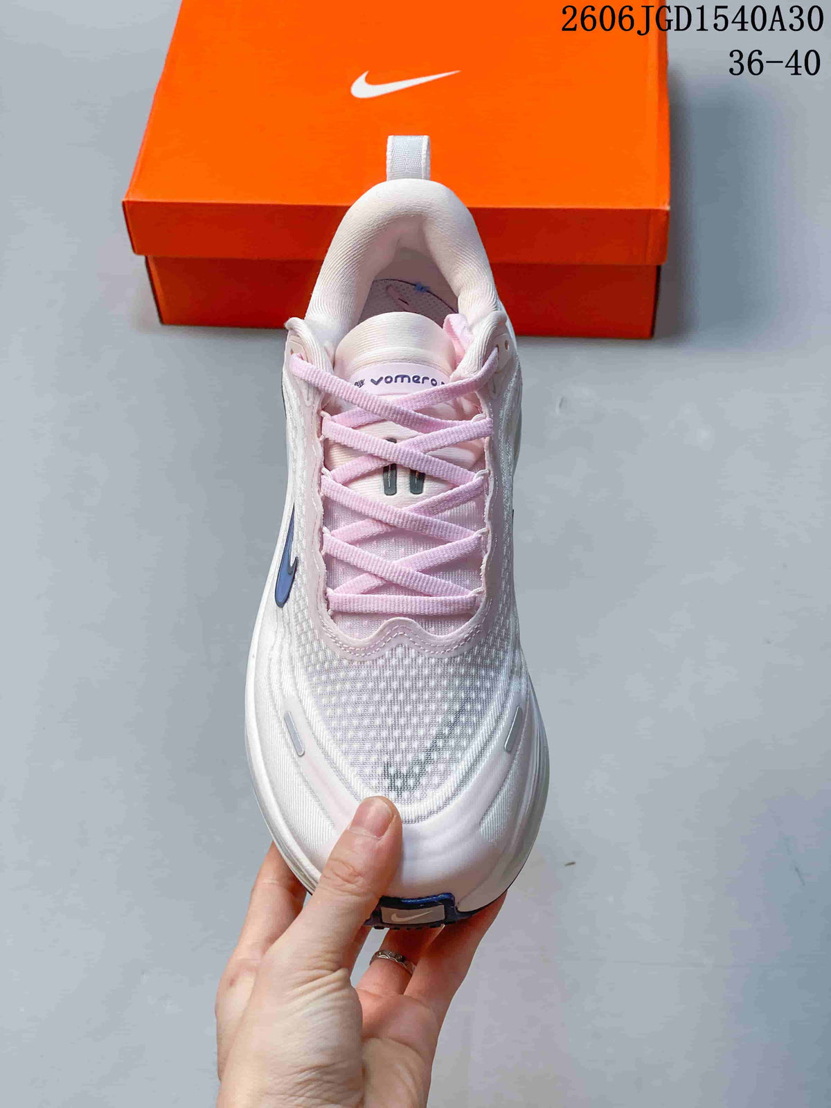 Top view of a Nike Vomero Plus shoe with pale pink laces and a textured white upper.