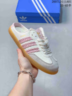 Angled side view showing the Samba marking, pink decorative stripes and grey toe overlay