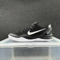 Side view of a black Nike low-top basketball sneaker with white side logo and outsole