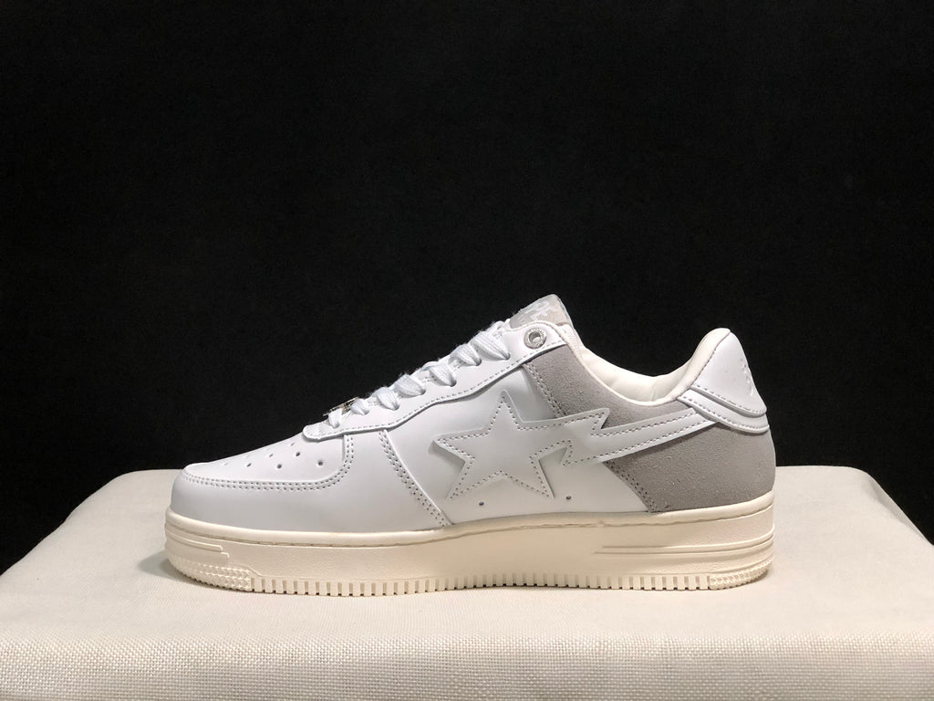 Side view of a single white and gray low-top sneaker with a star side detail and layered outsole.