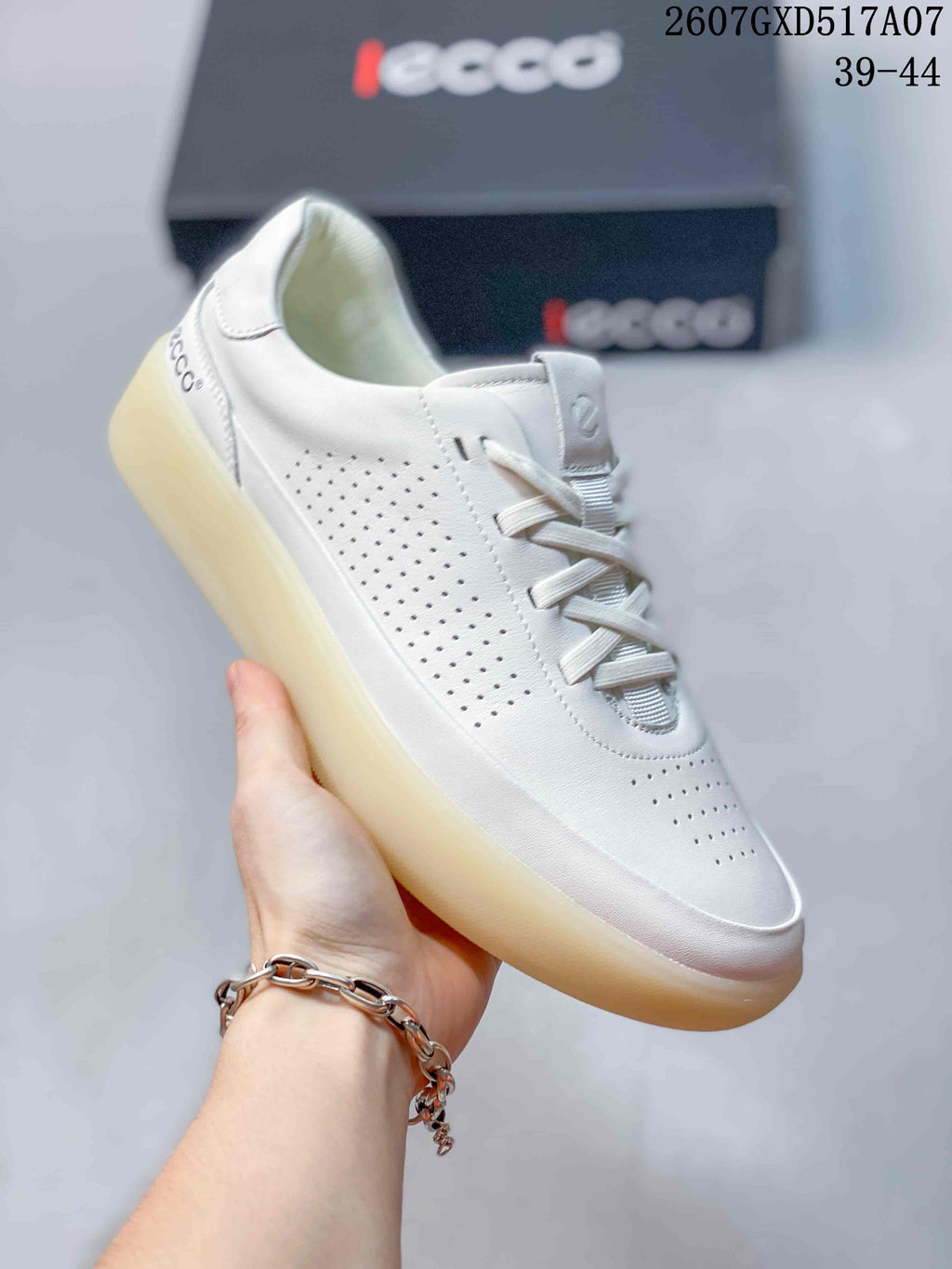 Angled side view of a white ECCO sneaker showing perforated panels, flat laces and the translucent outsole.