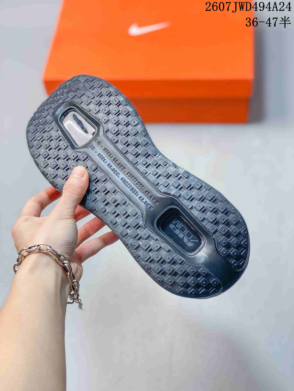 Bottom view of a sneaker showing the textured black outsole and visible cushioning window.