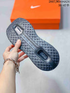 Bottom view of a sneaker showing the textured black outsole and visible cushioning window.