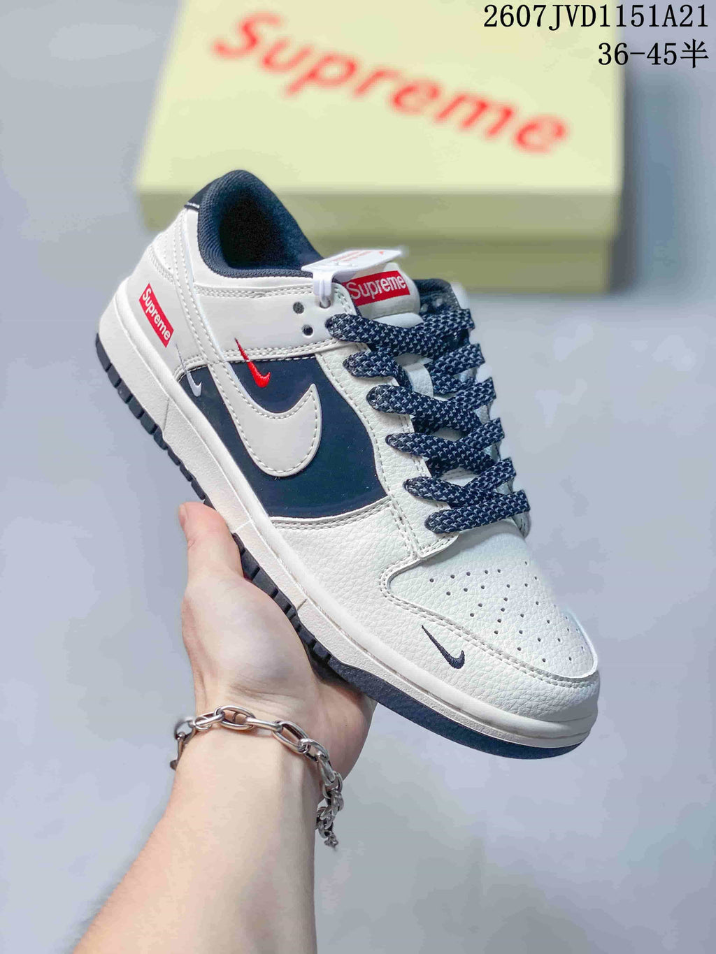 Angled side view showing the white and navy upper, contrasting Swoosh, red details and dark outsole.