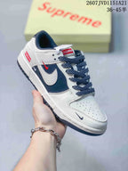 Angled side view showing the white and navy upper, contrasting Swoosh, red details and dark outsole.