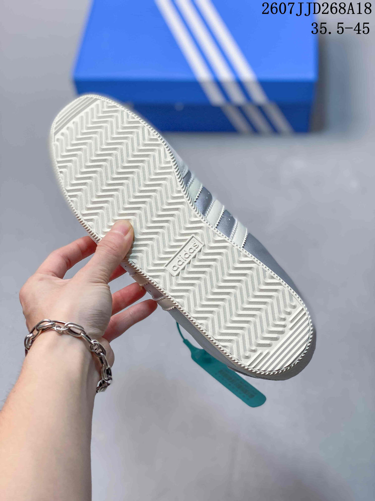 Close view of the white rubber outsole showing a repeating zigzag tread pattern and adidas branding.
