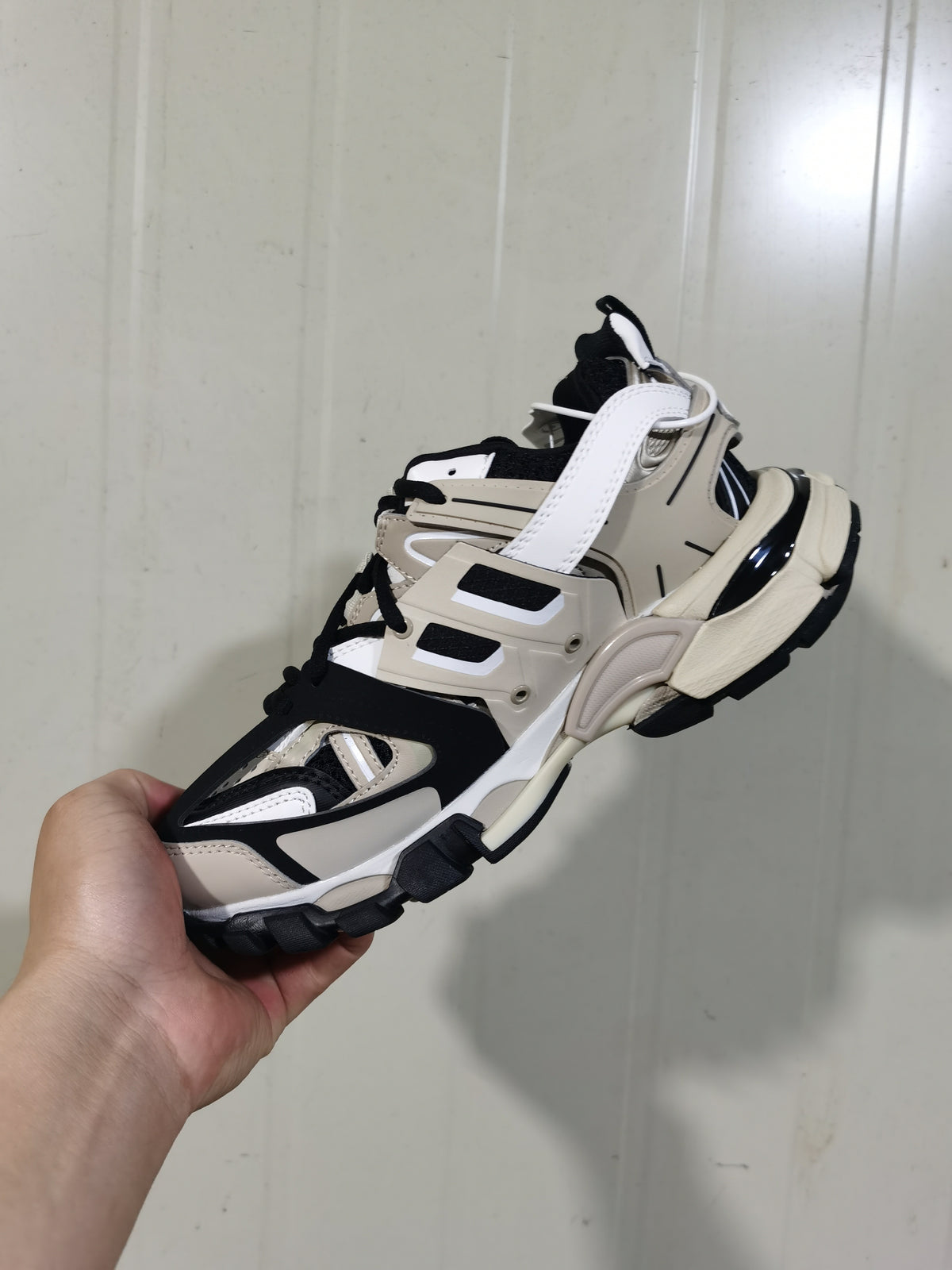 Rear and side view of the beige and black Balenciaga Track sneaker showing layered panels and the segmented outsole.