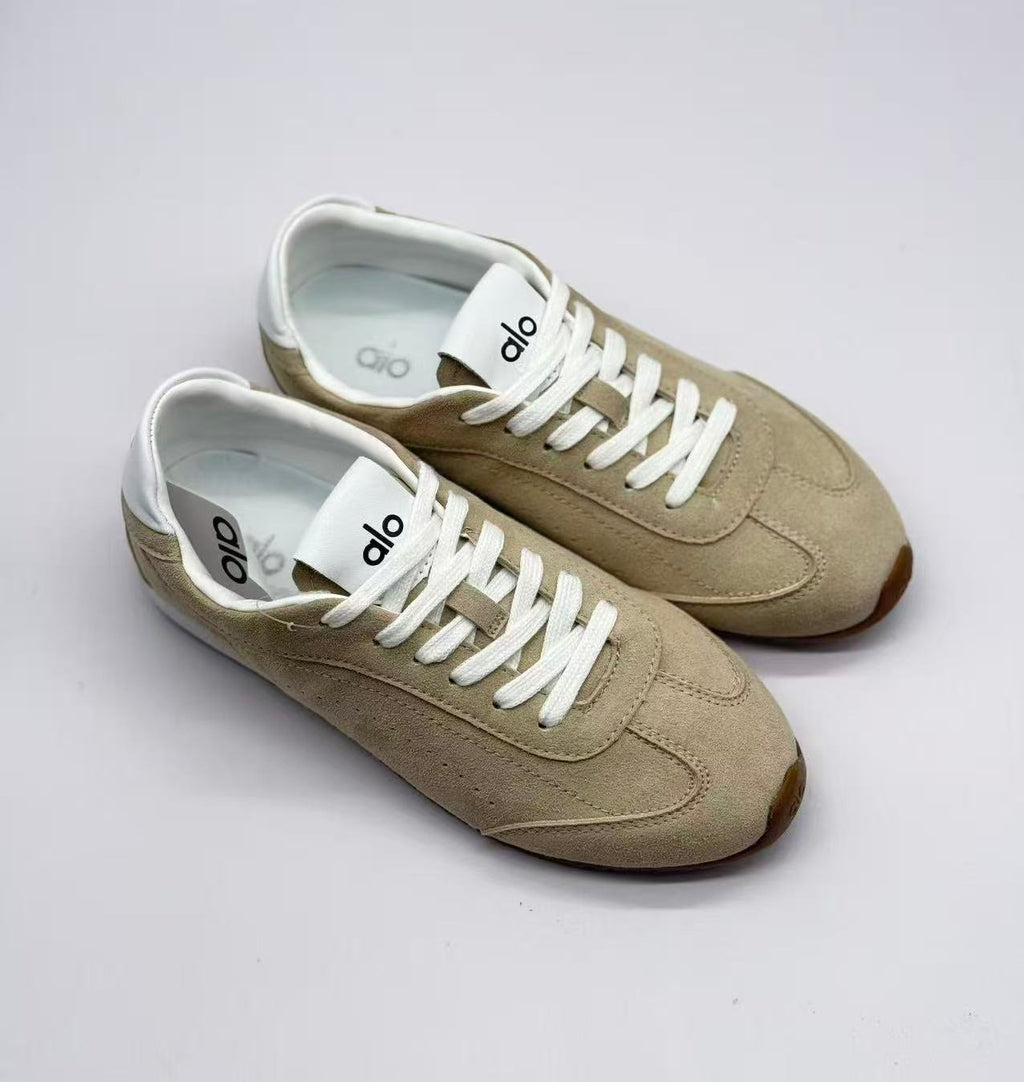 Top three-quarter view of the pair showing the white tongues and Alo branding.