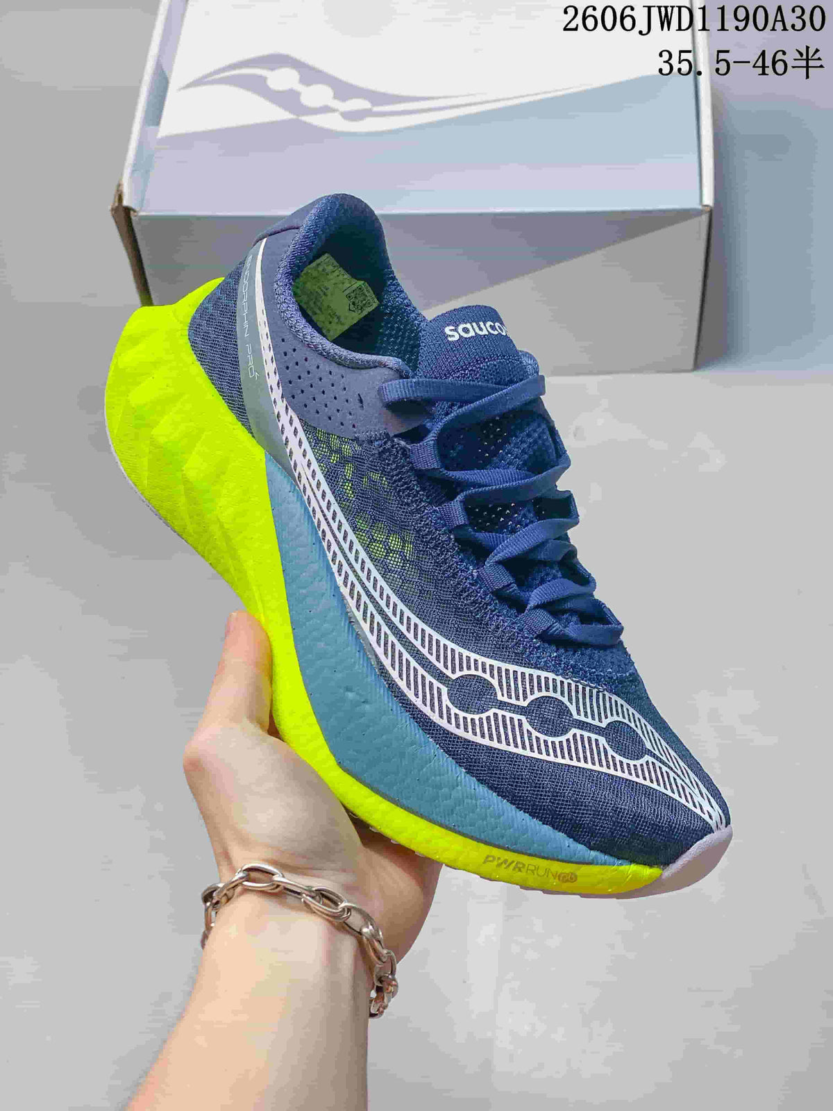 Navy Saucony running shoe with neon yellow sole accents and patterned side detail
