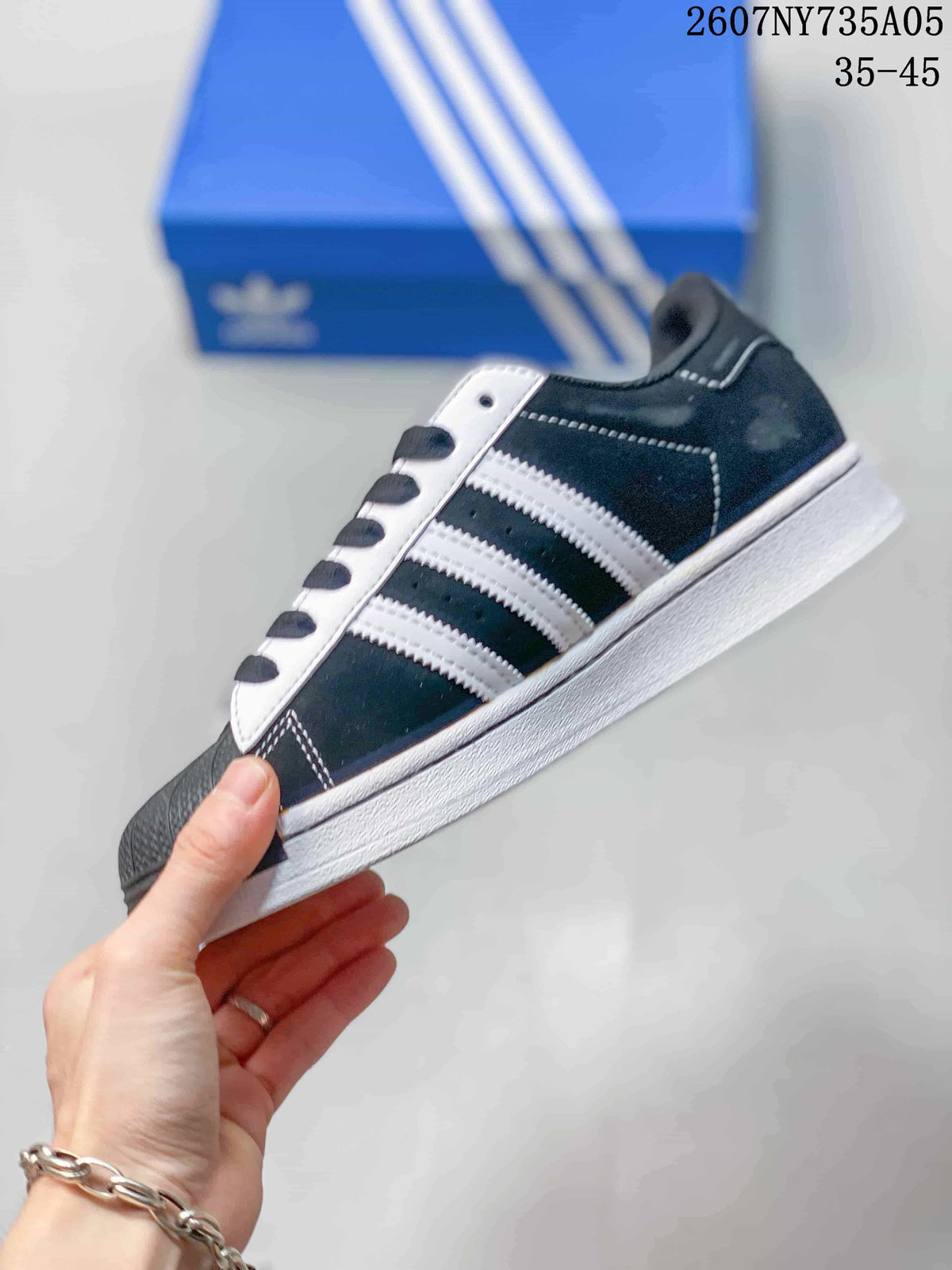 Side profile showing the black upper, three white stripes, black laces, and white outsole.