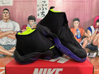Angled view of paired black Nike basketball sneakers showing neon yellow lining, purple outsole sections, and contrasting Swoosh details.