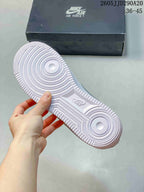 White sneaker outsole showing circular tread patterns and textured rubber edges, with a Nike Air Force 1 shoebox in the background.