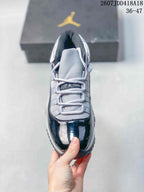 Top view of the sneaker showing grey laces, padded tongue, dark navy toe panel and contrasting upper details.